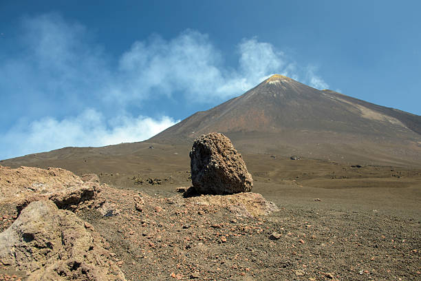 Mount Etna under a clear blue sky on a sunny day in Sicily, Italy. Majestic active volcano landscape with dramatic slopes and natural scenery, popular travel destination in Europe.