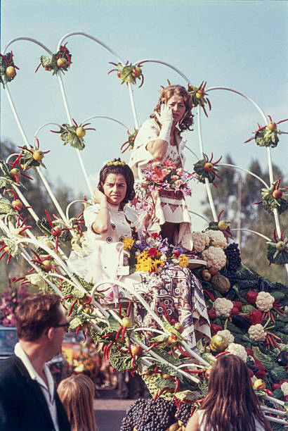 Historical slide showing a decorated float during the Harvest and Fruit Parade (Oogst- en Fruitcorso) in Tiel in the 1960s. The float, adorned with fruit, vegetables and natural materials, passes spectators lining the street. The annual parade in the Betuwe region is known for its elaborate fruit decorations and festive procession. September 1968, Tiel, Gelderland, The Netherlands.