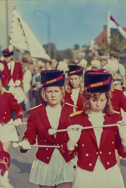 Majorettes of the Majorette, Drum and Trumpet Corps Sandido from Hendrik-Ido-Ambacht march during a parade in Tiel. Founded on August 31, 1967 on the initiative of the Wilhelmina-Juliana Orange Association, the corps performs in red uniforms with white accents and bearskin-style hats. The image captures a traditional Dutch village parade in the 1960s. September 1968, Tiel, Gelderland, The Netherlands.