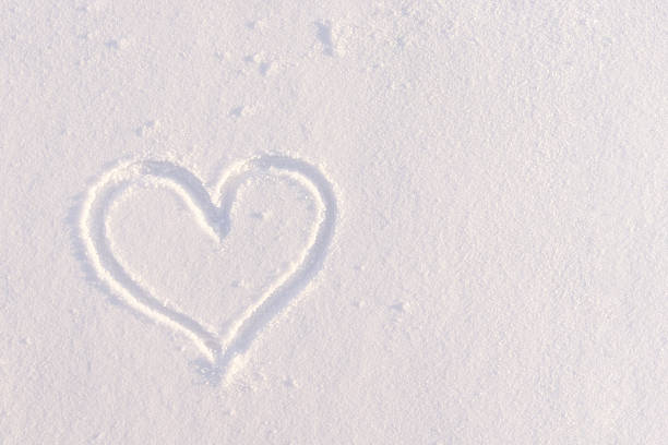 Heart symbol drawn on white snow romantic winter love concept with copy space