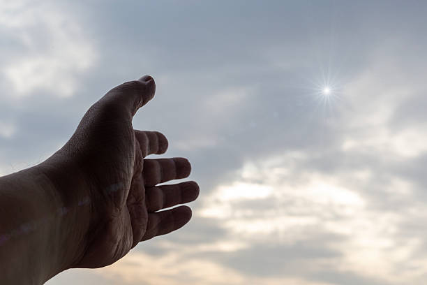 istock Hand pointing upward to the sky with a star among clouds, close-up. 2261242481