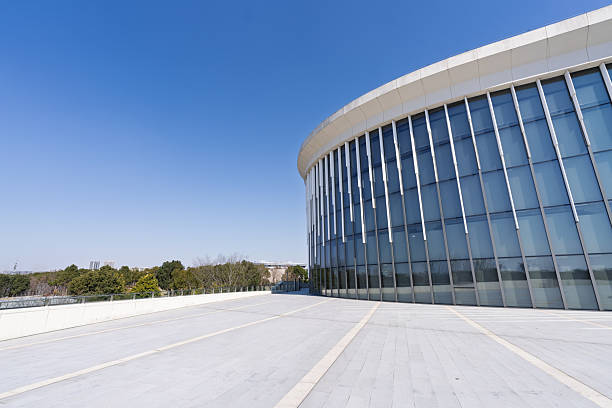 Shanghai Nine Trees Art Center, Modern glass facade office building with open plaza and clear blue sky