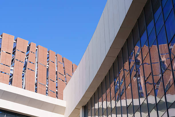 Modern Glass Office Building with Architectural Facade and Blue Sky Reflection