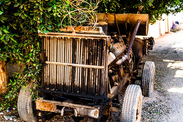 Rusty industrial generator abandoned along a quiet street in Giza, Egypt, surrounded by vegetation, showing urban decay, infrastructure aging, and environmental contrast.