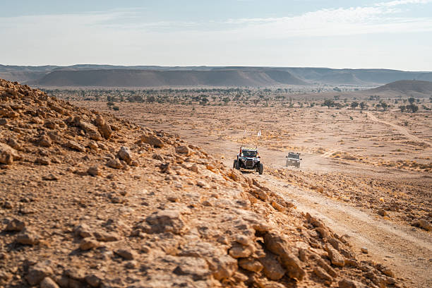 Some off-road vehicles driving in the dunes of the Saudi Arabian desert.