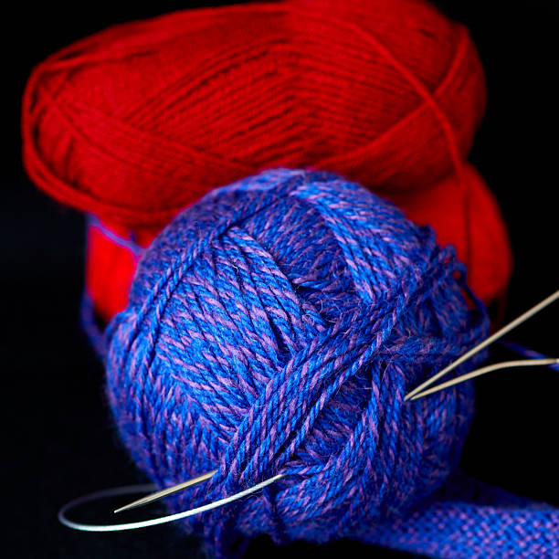 women is knitting amigurumi on the armchair amigurumi figures are in a basket on floor