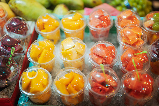 variety of sliced fruit displayed for quick consumption reflecting asian street market convenience food, wellness eating habits and colorful culinary presentation popular among travelers.