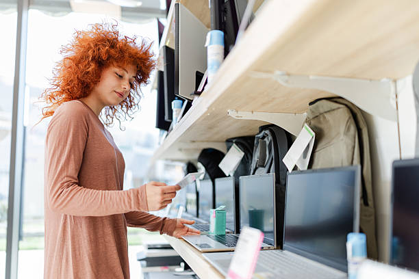 istock People shop for technology at an electronics store during the day while looking at laptops and accessories on display 2261259388