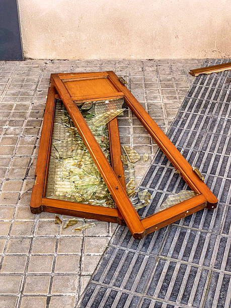 High angle close-up view of a broken wooden display cabinet door lying on the sidewalk