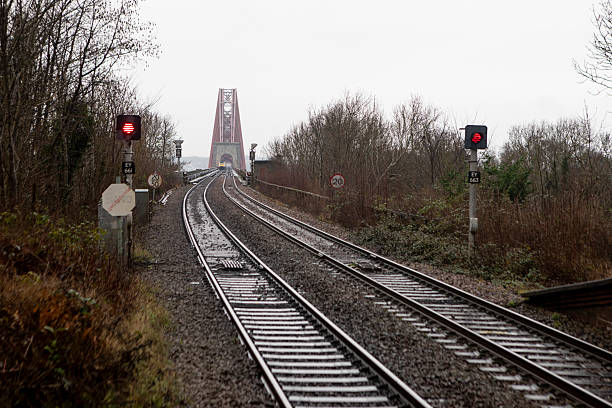 The Forth Bridge is a cantilever railway bridge across the Firth of Forth in the east of Scotland, west of Edinburgh. It is an iconic symbol of Scotland and is a UNESCO World Heritage Site. The imposing structure, which combines strength with beauty, dominates the landscape. Photo taken at Dalmeny railway station in winter.
