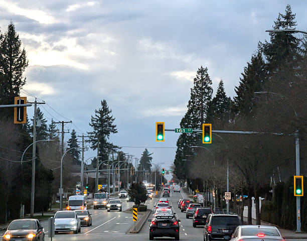 Surrey, Canada - February 6, 2026: Looking west from 96th Avenue at 161st Street. Afternoon rush hour traffic goes through the Fleetwood-Tynehead neighbourhood. Commercial and residential buildings line this street. Dramatic mid-winter sky above Metro Vancouver.