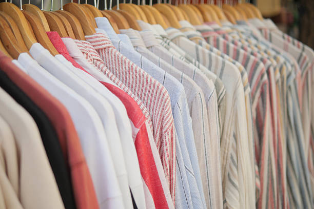 A variety of shirts hangs neatly on hangers in a store.