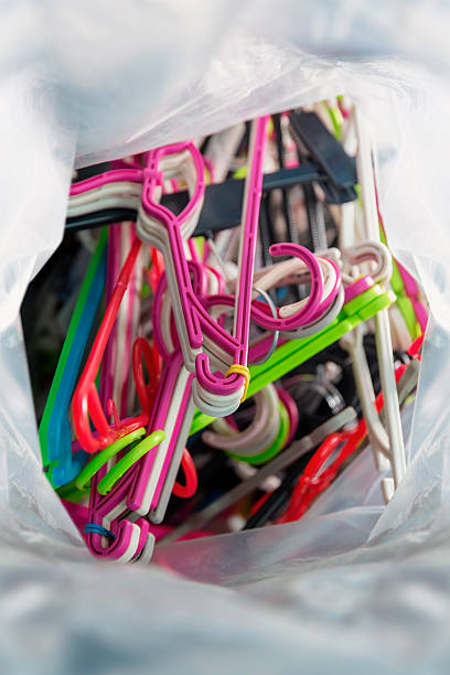 Multiple plastic hangers in vibrant colors filling a transparent bag, creating a cluttered storage