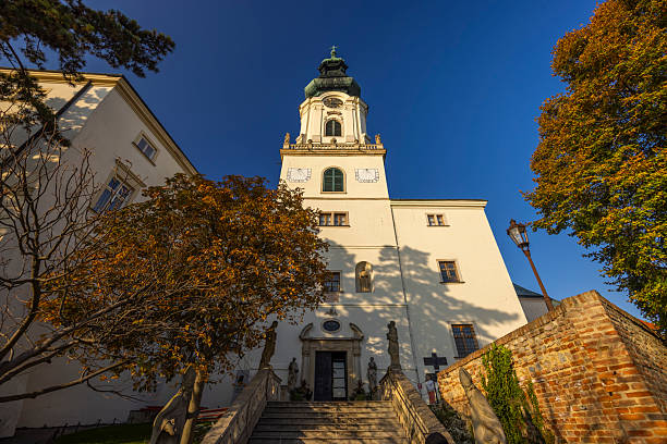 Ancient cathedral tower bathed in golden autumn sunlight in Nitra, Slovakia