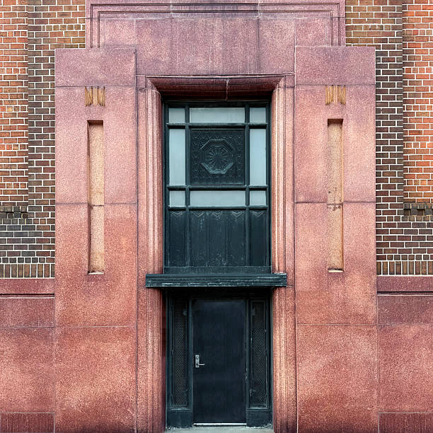 Art Deco building entrance metal door framed in polished red granite and geometric detailing on a Chicago facade.