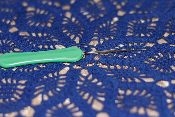 Close-up knitting on needles, warm yarn color, macro shot.