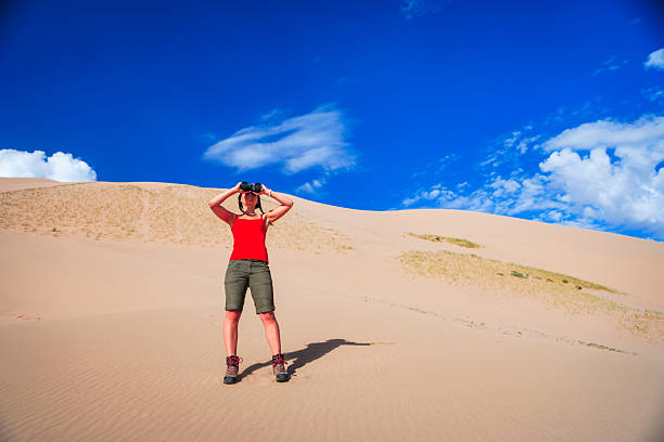 A young boy dressed in business suit and tie looks through a telescope at the White Sands National Monument in New Mexico, USA. He is looking for success in the future of his business.