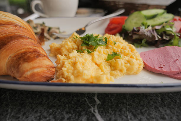 Scrambled eggs and fried egg on the table for breakfast