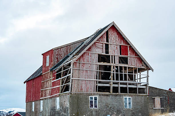 Dilapidated red wooden barn standing in a snowy winter landscape in lofoten, norway