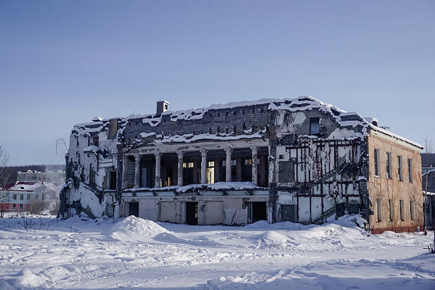 An old worn and torn toilet house in winter forest,