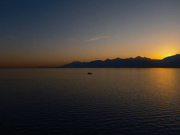 Golden sunset with mountain silhouette and peaceful ocean