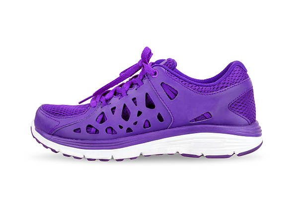 Sporty purple sneakers with white laces on  pink background