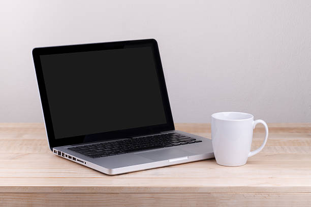 Front view of the laptop and coffee is on the work table concrete background