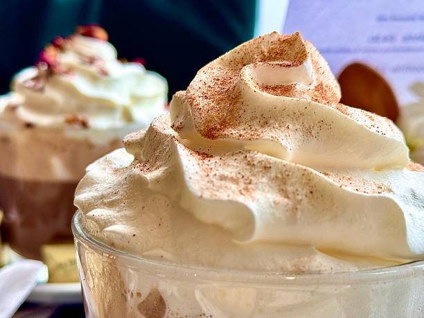 Close up of whipped cream on the top of hot drinks in a cafe