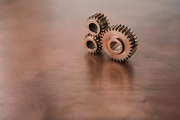 Metal gears of different sizes on a copper background. Clean composition with geometric rhythm, metallic textures, and warm tones creates a modern abstract industrial concept. Minimalism.