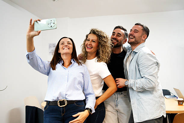 Friends taking selfie, laughing during team bonding moment