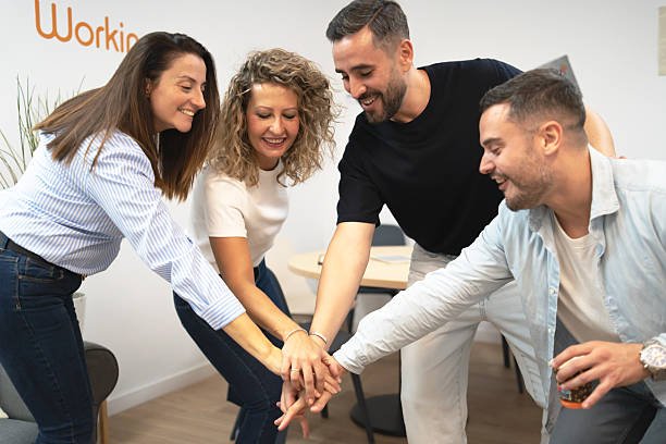 Business people stacking hands showing teamwork and collaboration