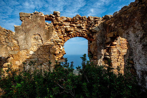 Ancient stone ruins with an arched opening overlooking the landscape in Sant'Antonino, Corsica, France, photographed in daylight for travel, heritage, and architectural use.