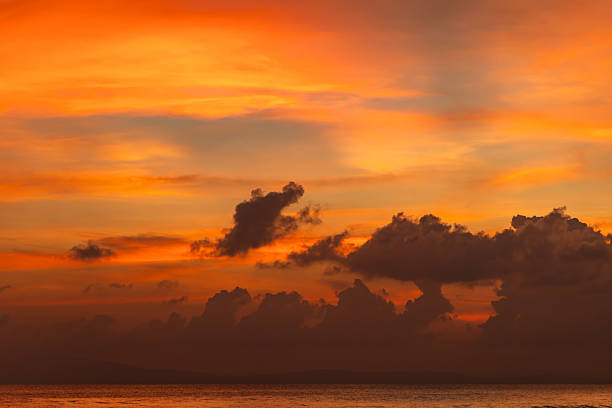 serene ocean sunset with orange sky and scattered clouds