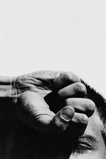 A close-up of a gorilla resting its hand on its own shoulder, showing the texture of its skin and fur. The image conveys calm strength and introspection in this intelligent primate.