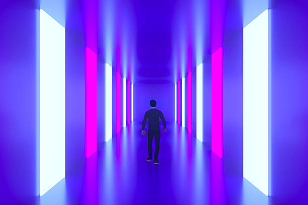 3D rendering of a male figure walking down a dark, futuristic hallway illuminated by vibrant vertical neon panels in pink and white. The clean perspective and deep blue-purple atmosphere symbolize data pathways, digital transformation, and the immersive experience of the metaverse. This visual serves as a perfect metaphor for entering the digital age, high-tech interior design, and the journey toward technological innovation. Ideal for cybersecurity banners, gaming backgrounds, and articles focusing on virtual environments or software development.