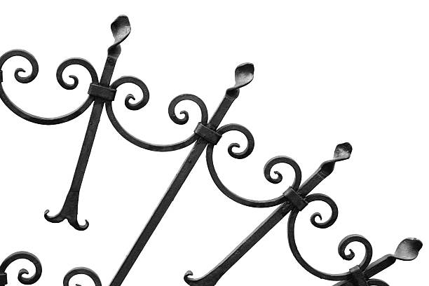 An ornate wrought iron gate featuring decorative patterns and pointed finials provides an elegant and secure design. This close-up image showcasing intricate craftsmanship suits architecture or home design themes.