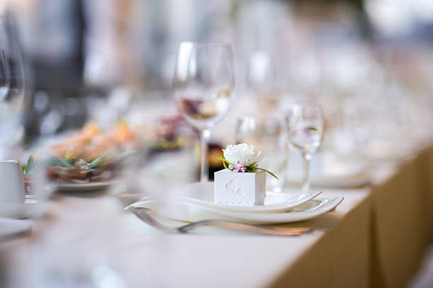 Elegant dining setup with floral accents. Table elegantly set with fine dining ware and delicate flowers, creating a charming atmosphere for a gathering.