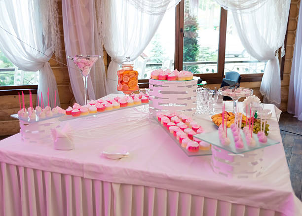 Festive dessert table display. Colorful desserts, including cupcakes and candies, beautifully arranged on a table with soft lighting.