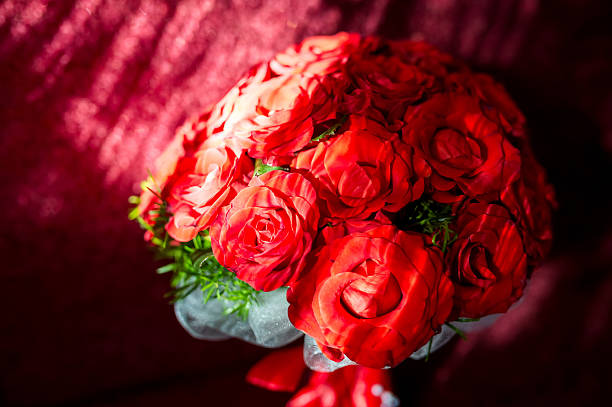 Red rose bouquet with leaves. Vibrant red roses arranged with greenery create a stunning floral display against a soft textured backdrop.