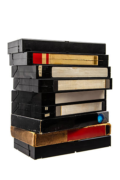 Stack of vintage VHS video cassettes with blank labels isolated on white background.