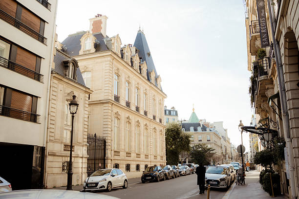 Paris, France – February 8, 2026 – View of a quiet Paris street featuring traditional Haussmann-style buildings and parked cars in a typical urban setting.