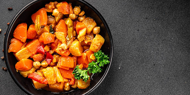 Stewed vegetables ragout potatoe, carrot, chickpea, onion, zucchini, pumpkin tasty snack fresh gourmet food background on the table rustic food top view copy space keto and paleo diet vegetarian and vegan foodmarketing concept photo