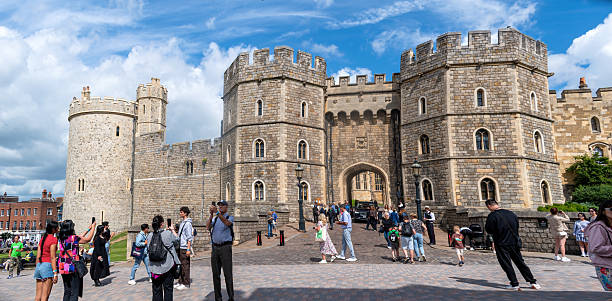 Windsor United Kingdom - August 12 2024;  Statue of Queen Victoria on path outside walls and architectural features of Windsor Castle