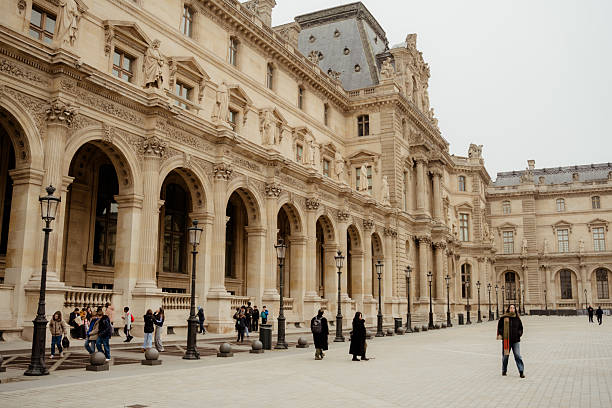 Paris, France - December 27, 2023:  Musee du Louvre with its pyramid and statue at sunset time, as viewed from an advantage point inside the museum.  HDR encoded