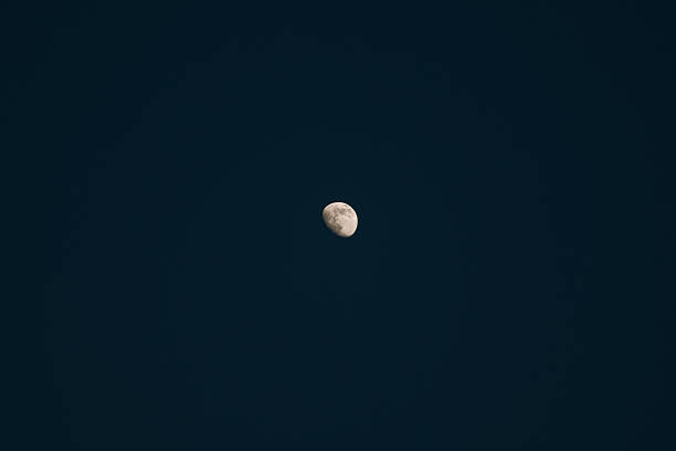 Gibbous moon against a dark, clear night sky, showing craters and illuminated surface. Astronomy and celestial themes