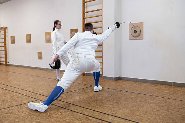 Young beginners, during training, hang out at a fencing course, get to know the sport, the equipment, and make new friends without phones. The trainees train accuracy with a sword strike on a target.