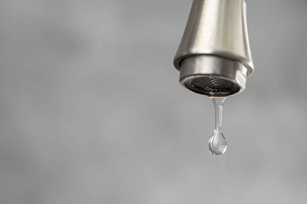 istock Water saving concept. Water dripping from tap on grey background, closeup. Space for text 2261486776