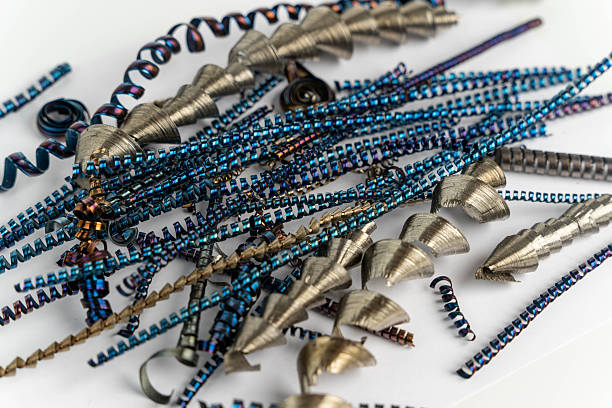 Metallic spirals and curls in blue and silver tones are scattered on a white background, highlighting their intricate designs and textures for crafting purposes