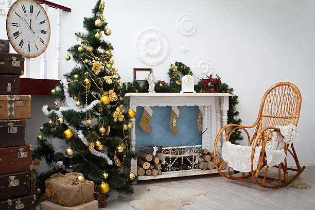 Classical Christmas decorated interior living room library with fireplace. Christmas tree with red golden ornament decorations. Modern classic style interior design apartment. Christmas eve at home