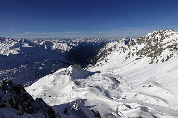 Aerial view of the valley and skiresort of St. Anton am Arlberg on a sunny day in Austria.  Sankt Anton am Arlberg, is a village and ski resort in the Austrian state of Tyrol. It lies in the Tyrolean Alps, with aerial tramways and gondolas up to 2,811 m. It is also a popular summer resort among trekkers and mountaineers.